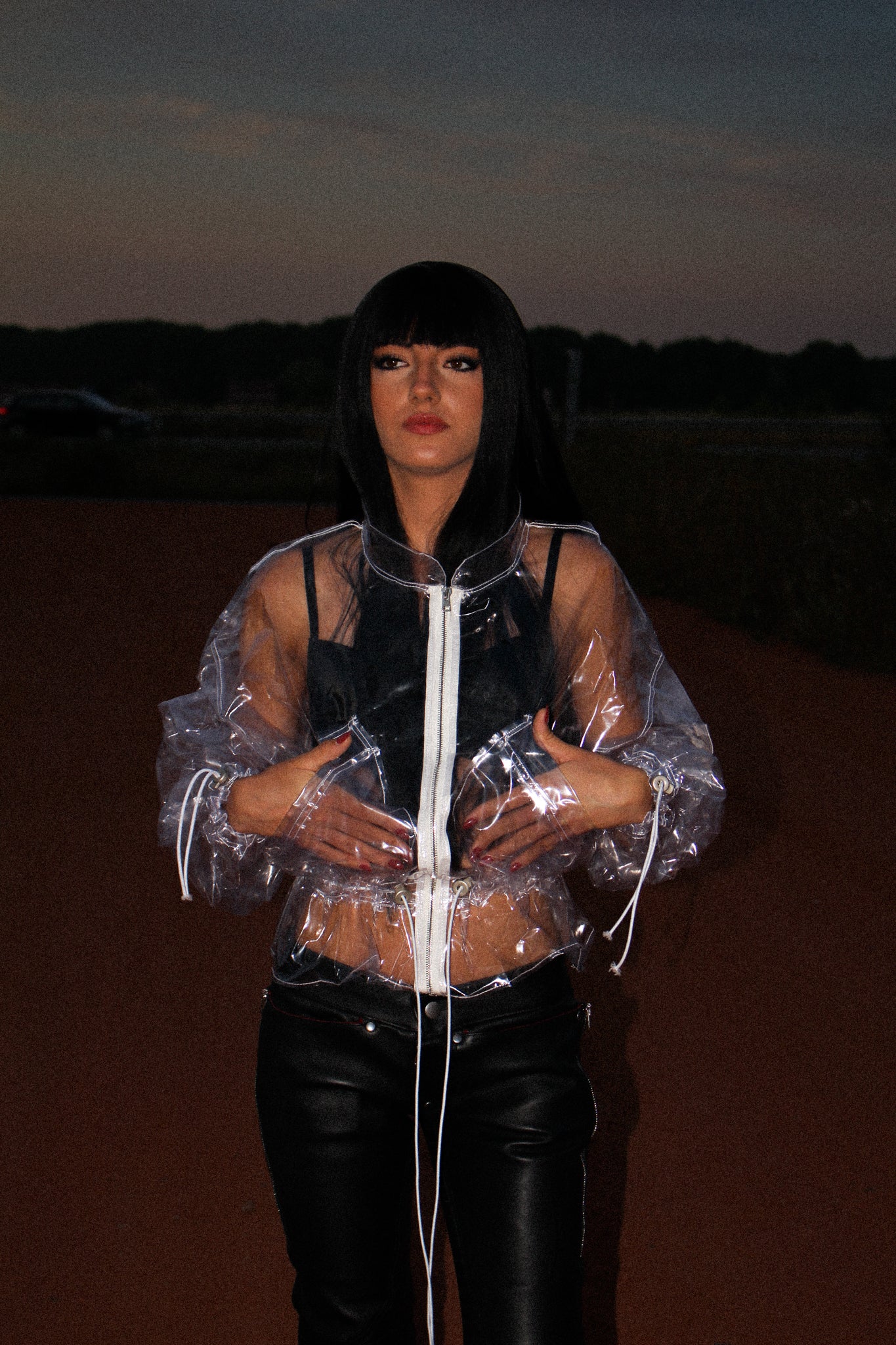 TRANSPARENT PVC CROPPED JACKET WITH A HIGH COLLAR, WHITE FRONT ZIP, ADJUSTABLE DRAWSTRINGS, RELAXED FIT AND CLEAR VINYL CONSTRUCTION.