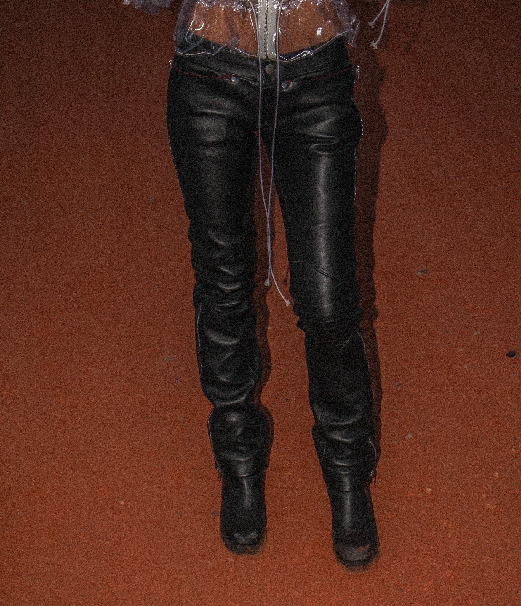 BLACK LOW-RISE LEATHER TROUSERS WITH A SLIM FIT, RED-PIPED ZIP POCKETS, REAR ZIP POCKETS, SIDE ZIP OPENINGS AT THE HEM AND SILVER HARDWARE.