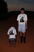 WHITE OVERSIZED GENTIL GARÇON GRAPHIC T-SHIRT FEATURING A FRONT AND BACK PRINT, SHOWN IN AN EDITORIAL CAMPAIGN WITH TWO MODELS IN A NIGHTTIME OUTDOOR SETTING.