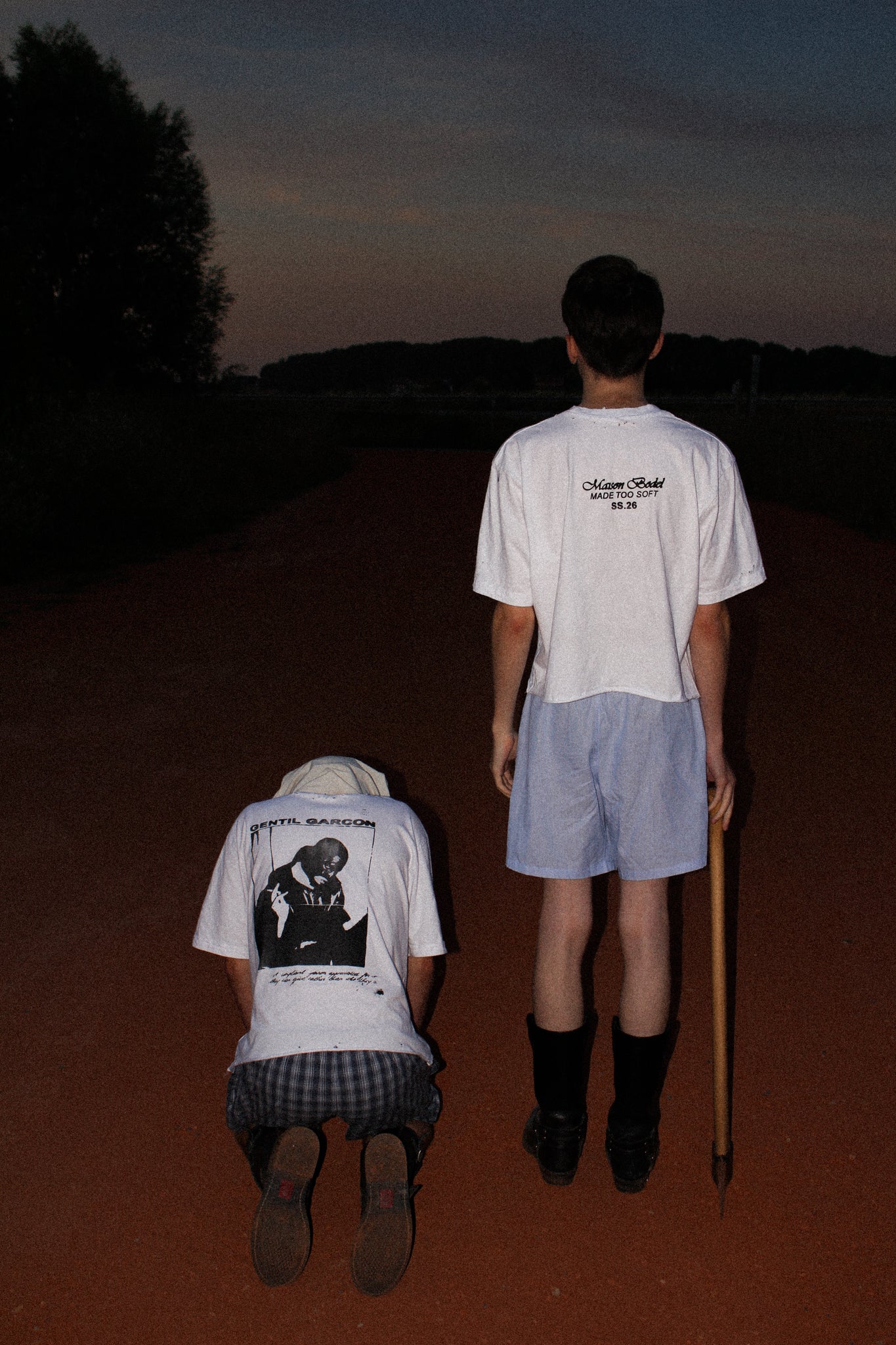 WHITE OVERSIZED GENTIL GARÇON GRAPHIC T-SHIRT FEATURING A FRONT AND BACK PRINT, SHOWN IN AN EDITORIAL CAMPAIGN WITH TWO MODELS IN A NIGHTTIME OUTDOOR SETTING.