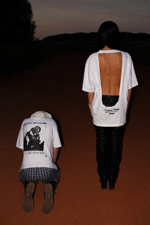 WHITE OVERSIZED T-SHIRT WITH A DEEP OPEN BACK, DISTRESSED DETAILS AND A MAISON BODEL “MADE TOO SOFT” GRAPHIC PRINT ON THE LOWER BACK.