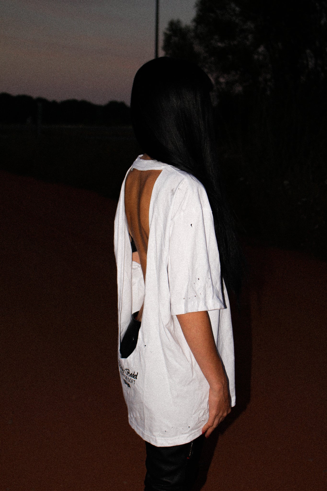 WHITE OVERSIZED T-SHIRT WITH A DEEP OPEN BACK, DISTRESSED DETAILS AND A MAISON BODEL “MADE TOO SOFT” GRAPHIC PRINT ON THE LOWER BACK.