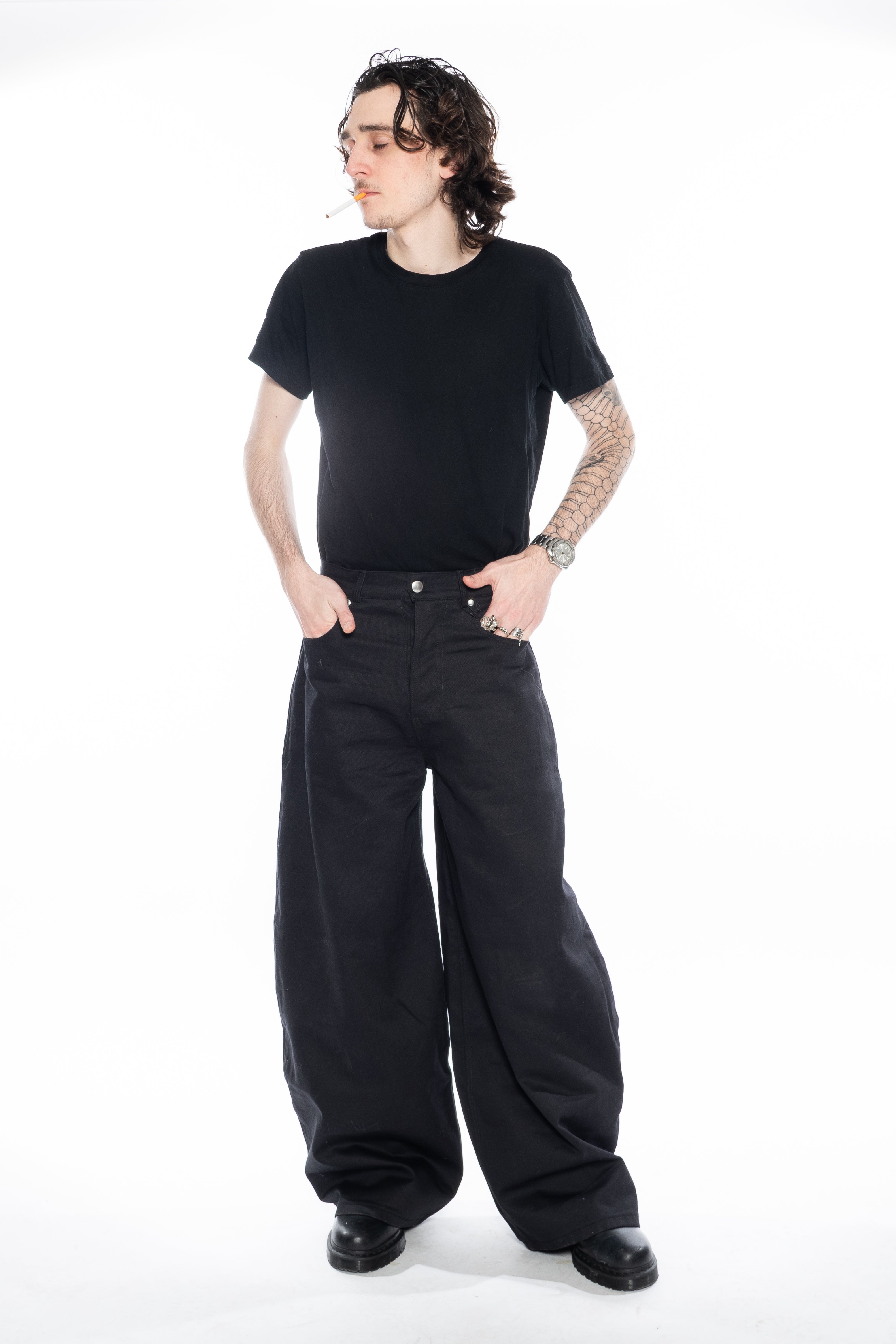 BLACK OVERSIZED CURVED-LEG JEANS WITH A LOW-RISE WAIST, FIVE-POCKET CONSTRUCTION, BUTTON FLY, SILVER HARDWARE AND A RELAXED SILHOUETTE.