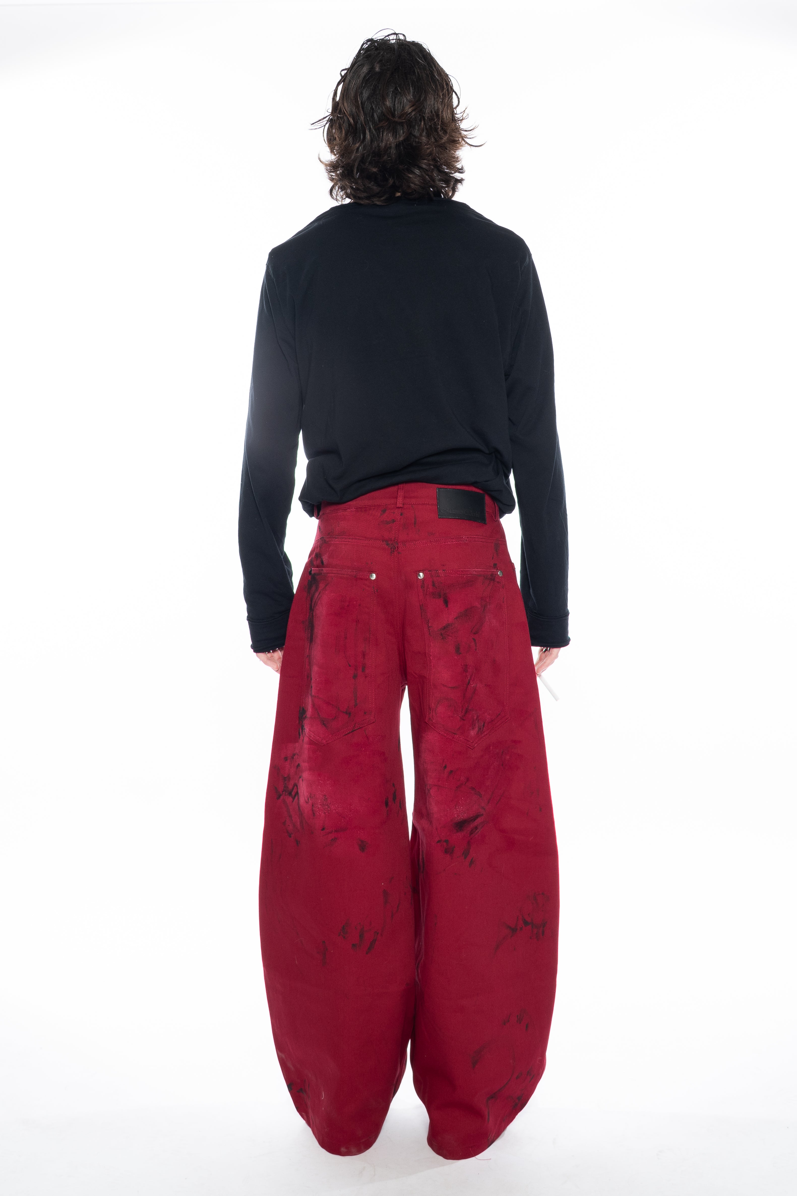 RED HAND-DYED OVERSIZED CURVED-LEG JEANS WITH A LOW-RISE WAIST, BLACK HAND-PAINTED DETAILS, FIVE-POCKET CONSTRUCTION, BUTTON FLY AND SILVER HARDWARE.
