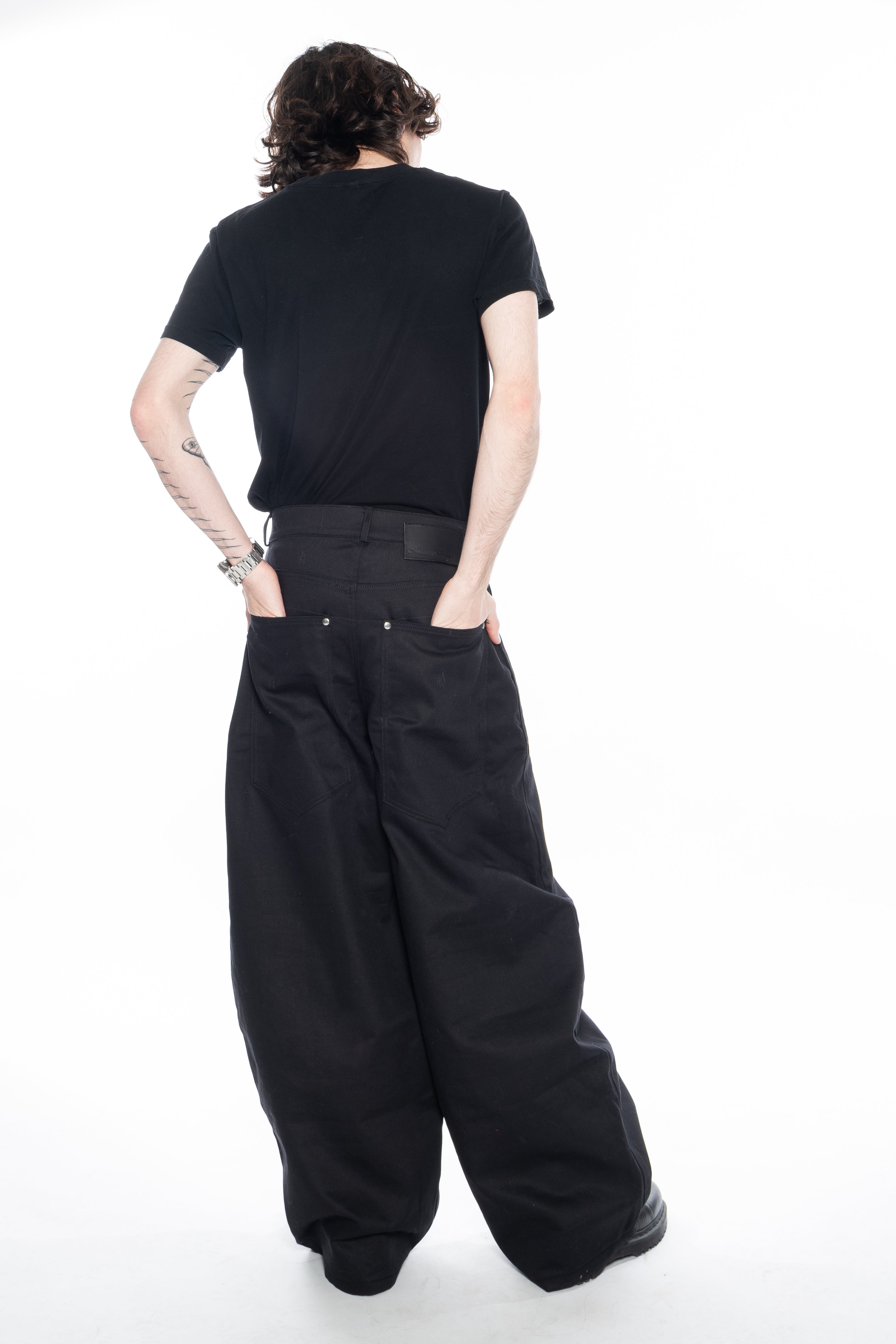 BLACK OVERSIZED CURVED-LEG JEANS WITH A LOW-RISE WAIST, FIVE-POCKET CONSTRUCTION, BUTTON FLY, SILVER HARDWARE AND A RELAXED SILHOUETTE.