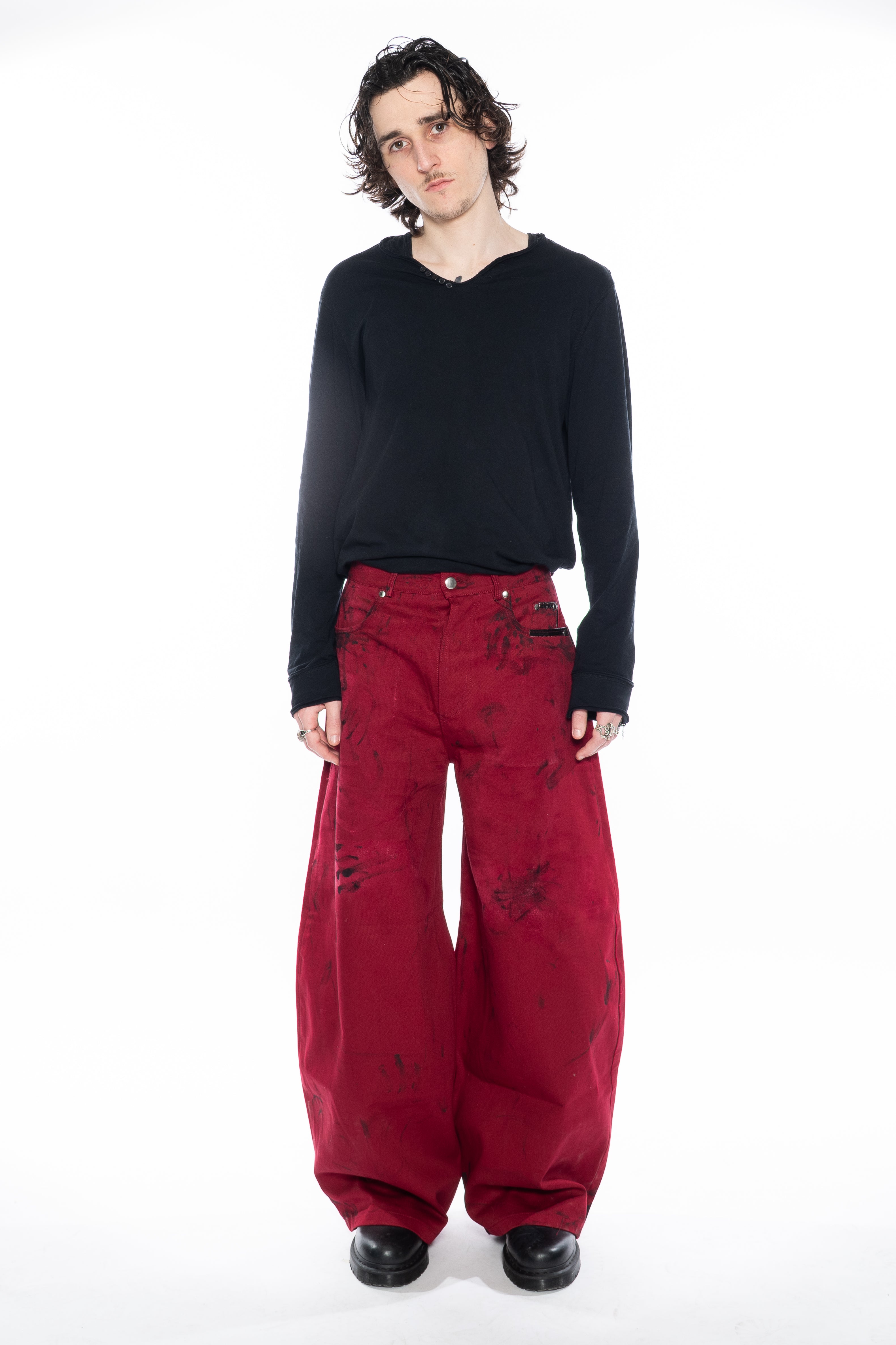 RED HAND-DYED OVERSIZED CURVED-LEG JEANS WITH A LOW-RISE WAIST, BLACK HAND-PAINTED DETAILS, FIVE-POCKET CONSTRUCTION, BUTTON FLY AND SILVER HARDWARE.
