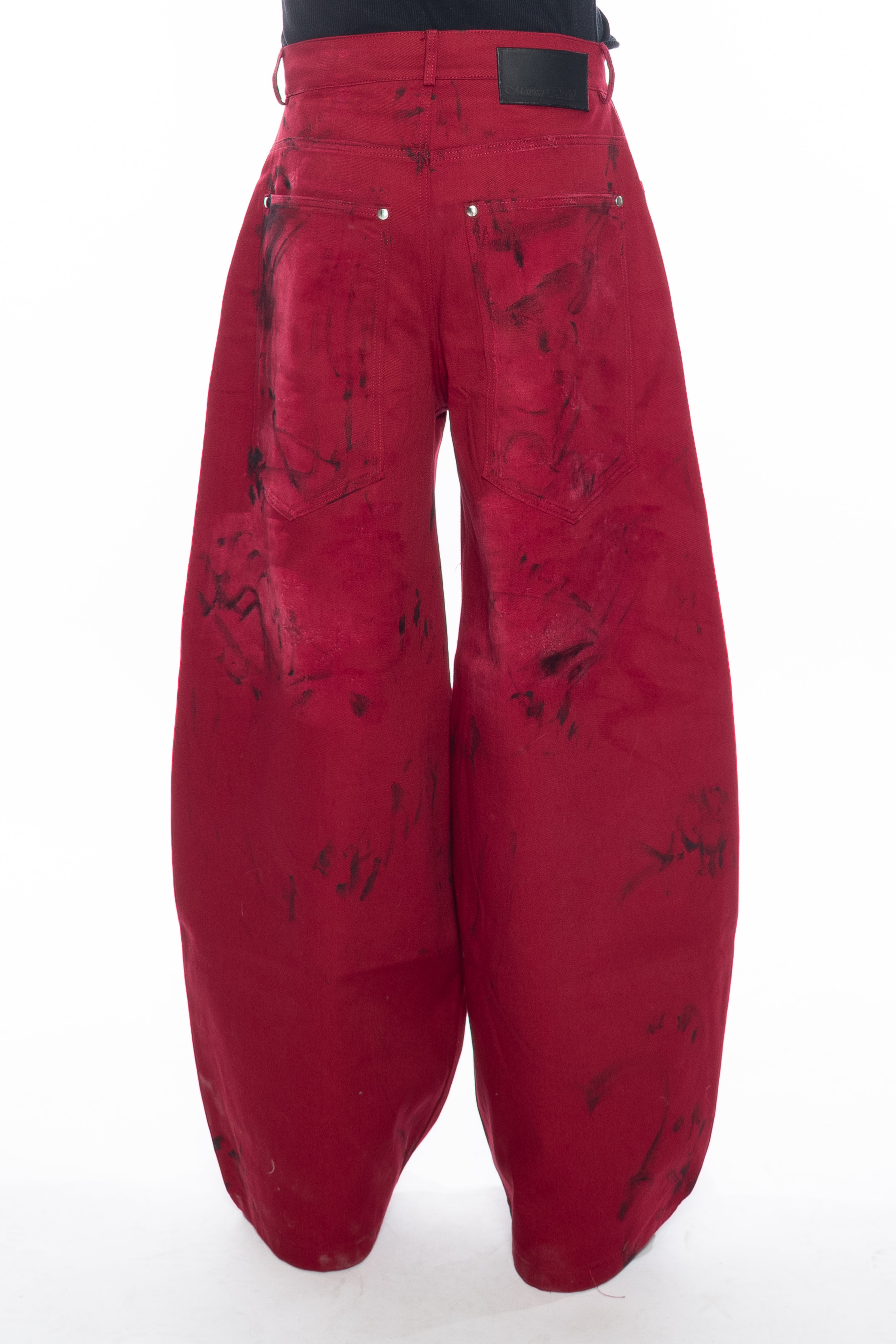 RED HAND-DYED OVERSIZED CURVED-LEG JEANS WITH A LOW-RISE WAIST, BLACK HAND-PAINTED DETAILS, FIVE-POCKET CONSTRUCTION, BUTTON FLY AND SILVER HARDWARE.