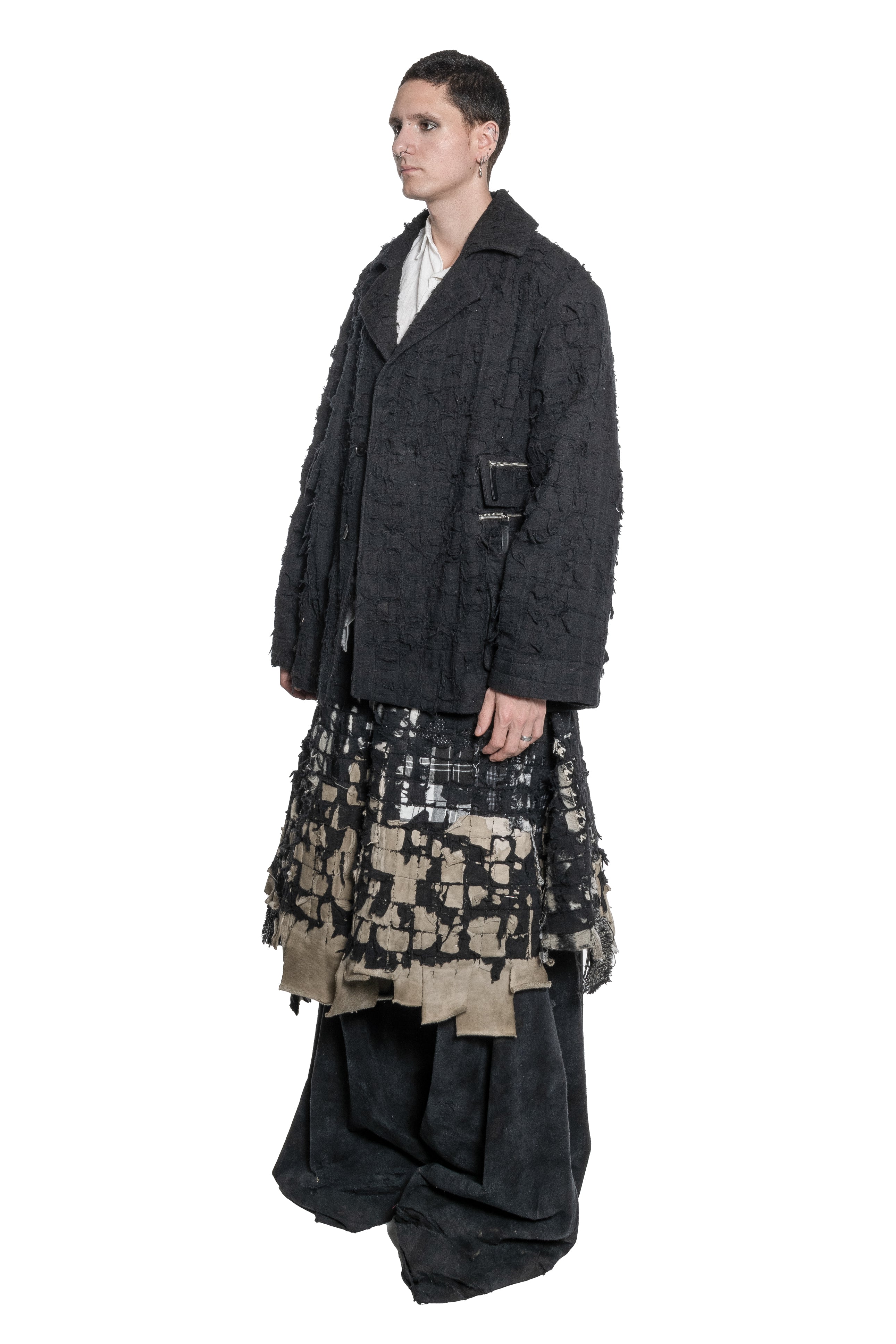 BLACK DISTRESSED TAILORED JACKET WITH FRAYED TEXTURE, OVERSIZED SILHOUETTE, MULTIPLE ZIPPED PATCH POCKETS, BUTTON FRONT CLOSURE AND RAW FINISHES.
